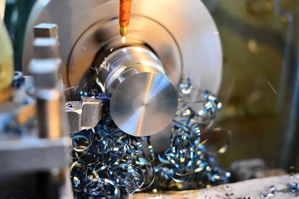CNC lathe precision-machining a steel shaft component with active coolant